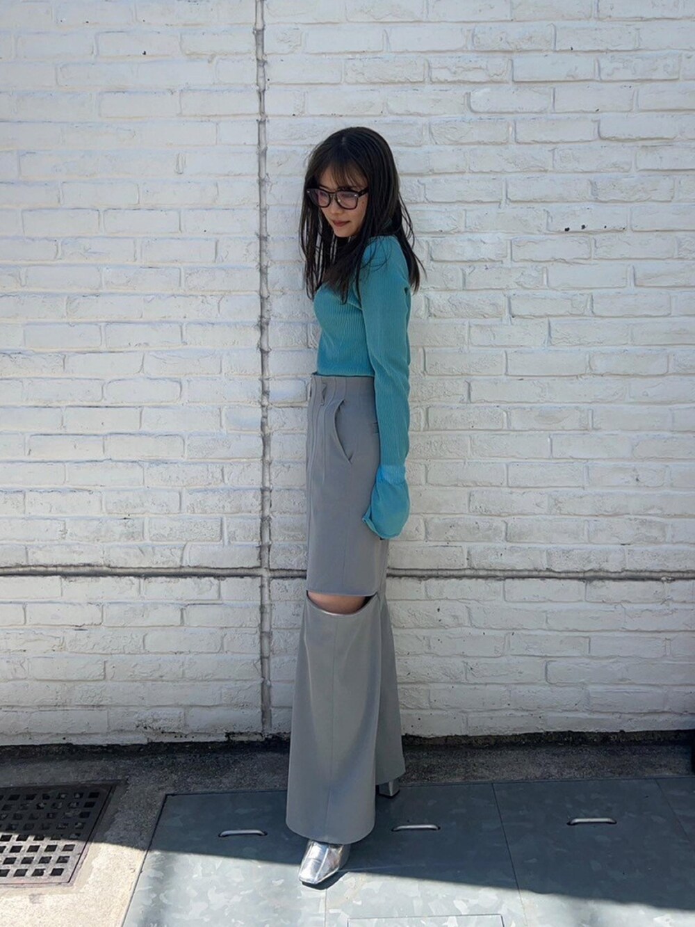 ブルー系のニット/セーター、グレー系のその他パンツを着用したレディースの春コーディネートの2枚目の写真