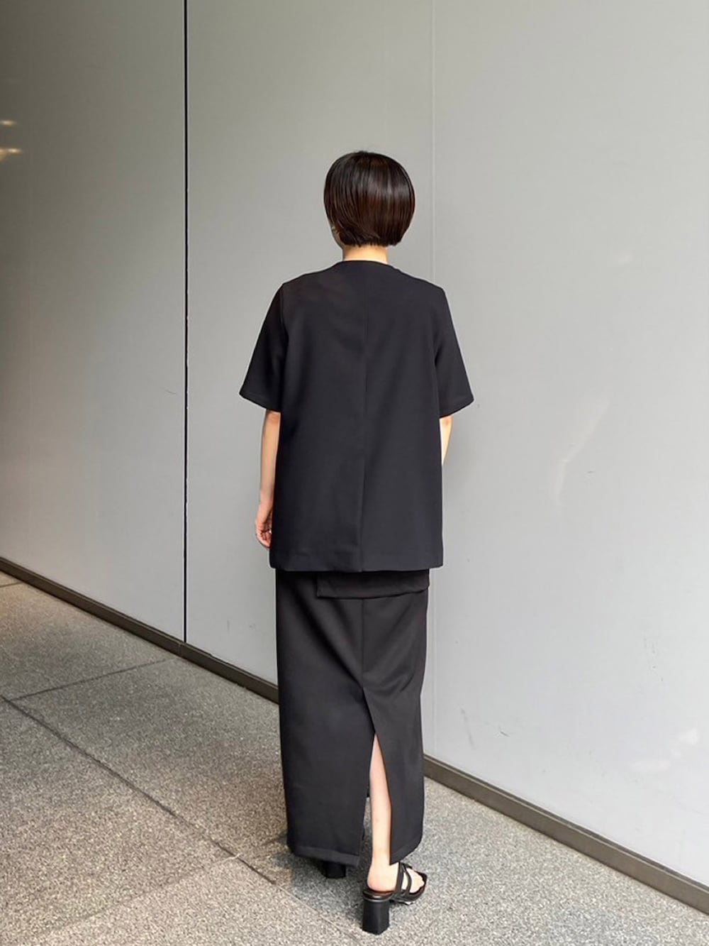 ブラック系のノーカラージャケット、グリーン系のスカートを着用したレディースの夏コーディネートの3枚目の写真