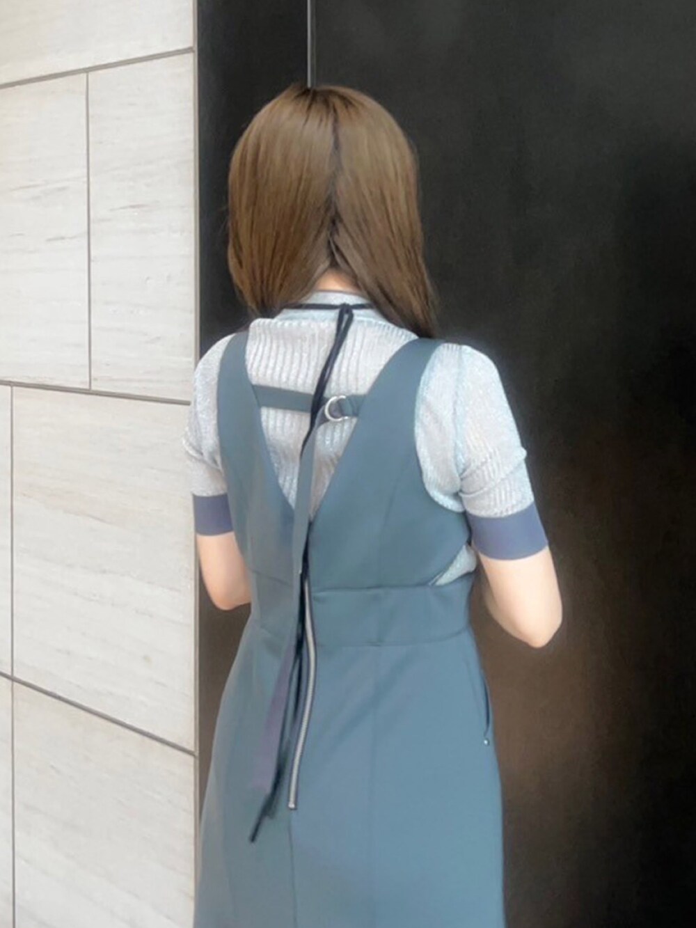 シルバー系のニット/セーター、グレー系のジャンパースカートを着用したレディースの春コーディネートの6枚目の写真