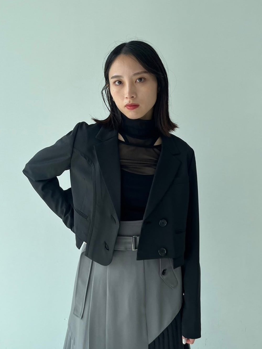 ブラック系のテーラードジャケット、グリーン系のスカートを着用したレディースの秋コーディネートの4枚目の写真