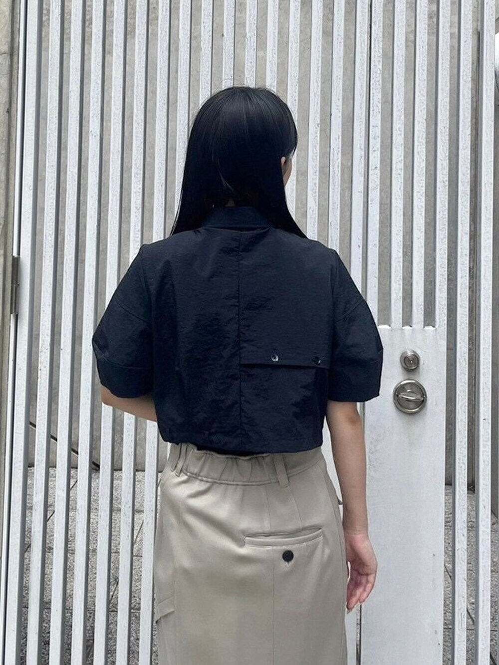 ブラック系のシャツ/ブラウス、ベージュ系のスカートを着用したレディースの春コーディネートの6枚目の写真