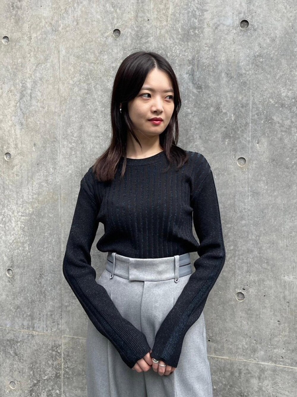 ブラック系のニット/セーター、グレー系のその他パンツを着用したレディースの秋コーディネートの4枚目の写真