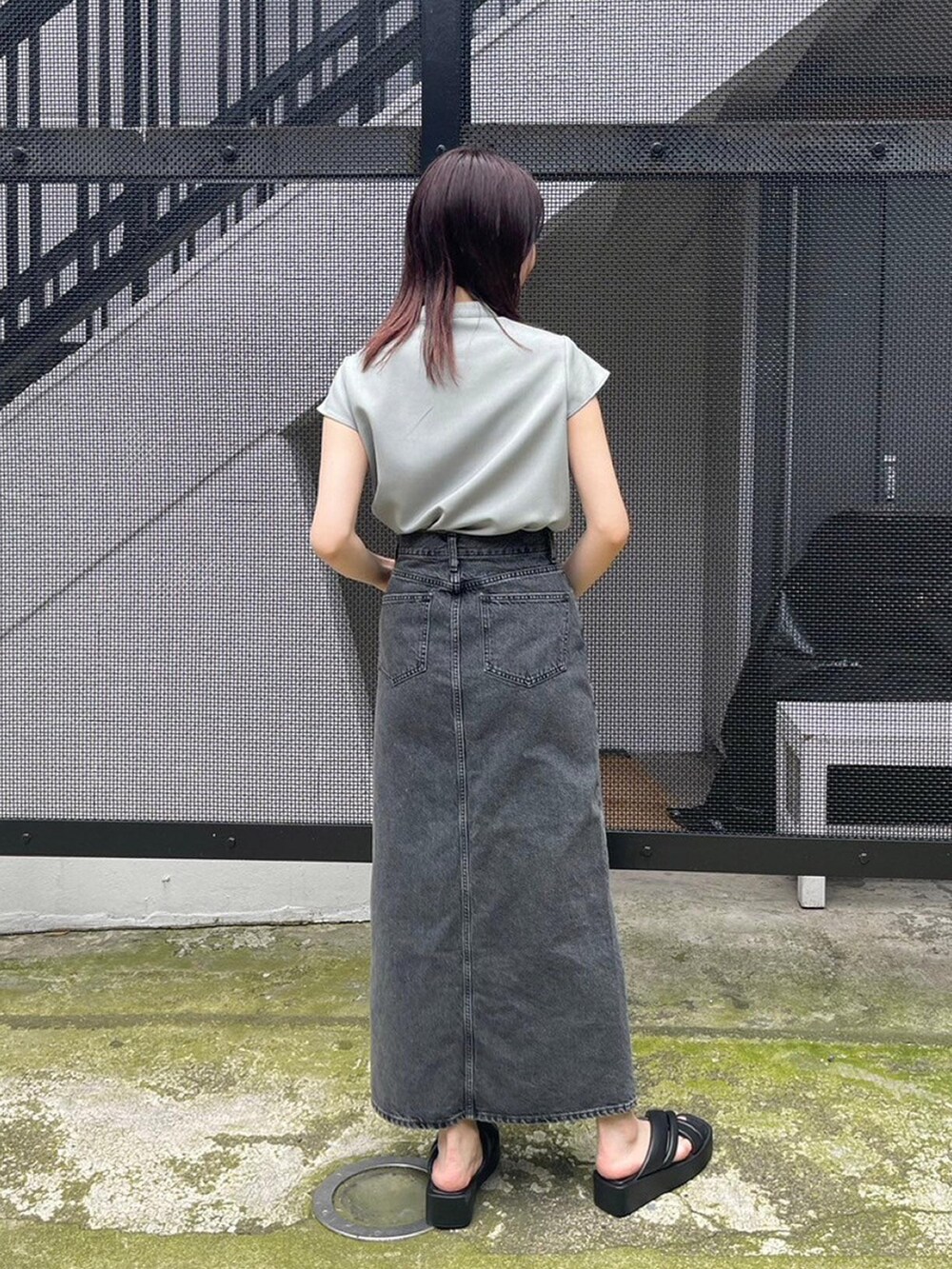 グリーン系のシャツ/ブラウス、ブラック系のデニムスカートを着用したレディースの春コーディネートの3枚目の写真