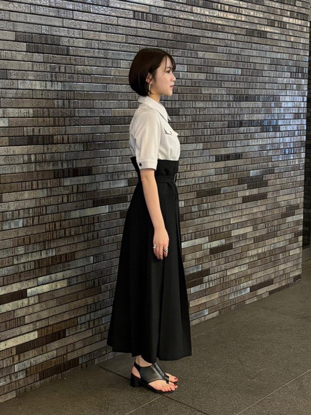 ベージュ系のワンピース、ブラック系のサンダルを着用したレディースの夏コーディネートの2枚目の写真