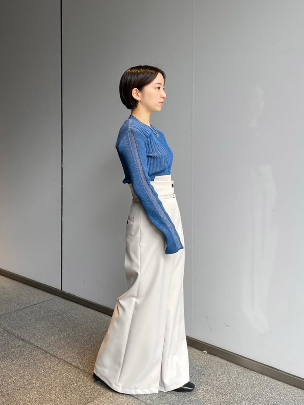 ブルー系のニット/セーター、ホワイト系のその他パンツを着用したレディースの秋コーディネートの2枚目の写真