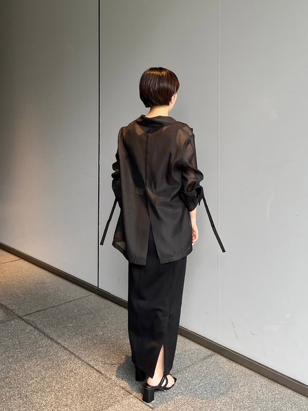 ブラック系のスカート、ブラック系のテーラードジャケットを着用したレディースの夏コーディネートの3枚目の写真