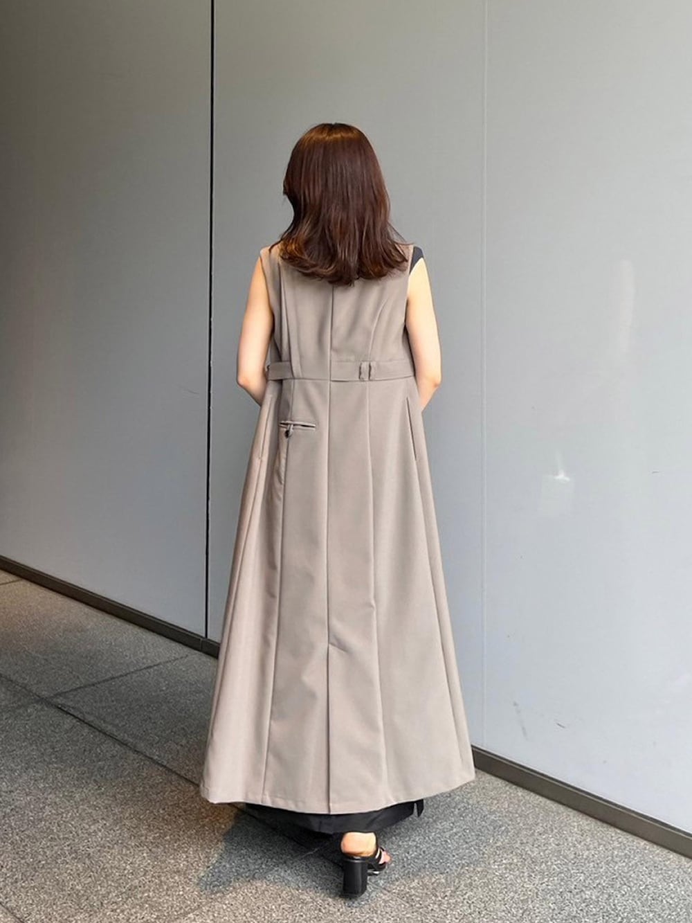 グレー系のタンクトップ、ブラック系のスカート、ベージュ系のワンピースを着用したレディースの夏コーディネートの3枚目の写真