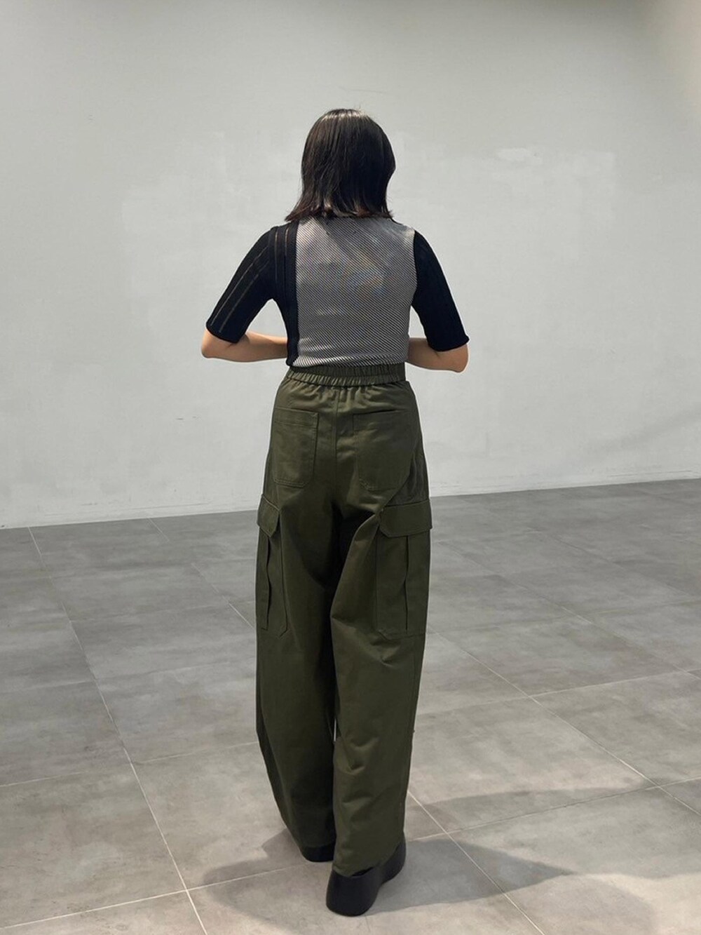 ブラック系のニット/セーター、グリーン系のカーゴパンツを着用したレディースの秋コーディネートの3枚目の写真