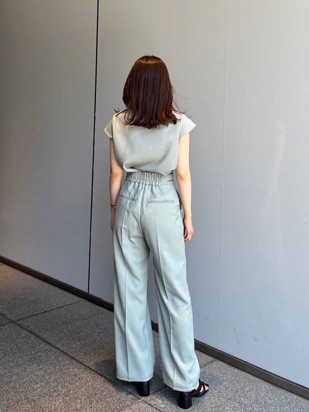 グリーン系のシャツ/ブラウス、グリーン系のスラックスを着用したレディースの夏コーディネートの2枚目の写真