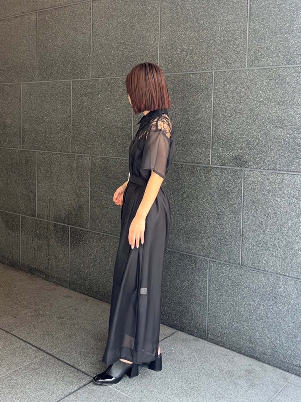 ブラック系のシャツワンピースを着用したレディースの夏コーディネートの2枚目の写真