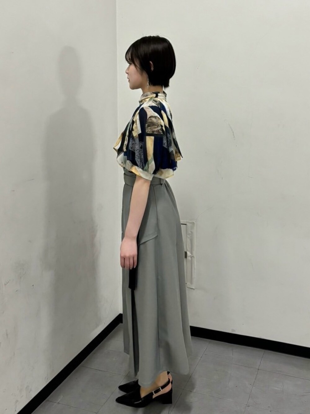 ブルー系のシャツ/ブラウス、グレー系のスカートを着用したレディースの春コーディネートの2枚目の写真