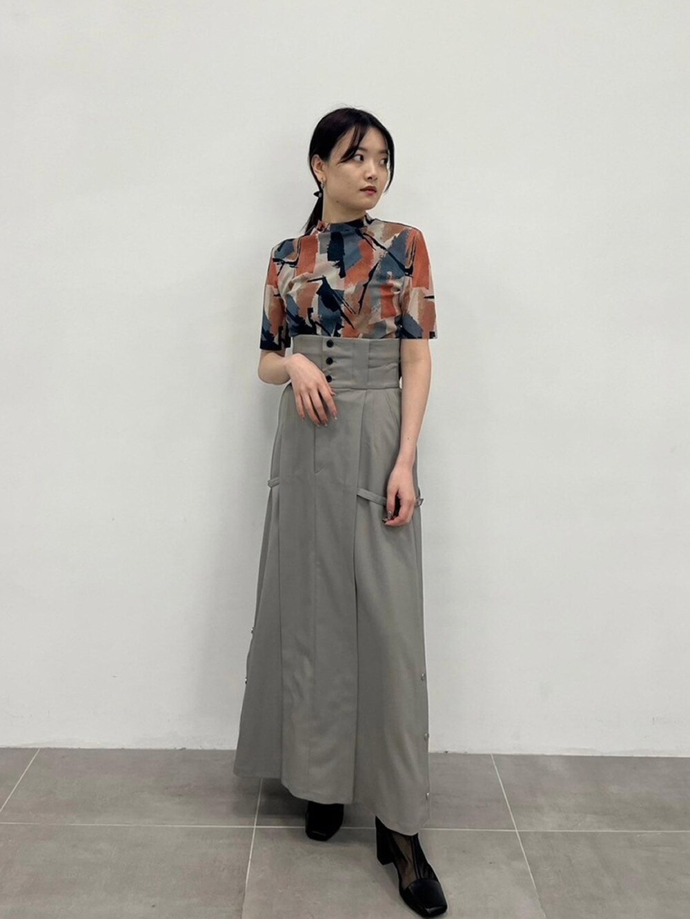 ベージュ系のTシャツ/カットソー、グレー系のスカートを着用したレディースの春コーディネートの3枚目の写真