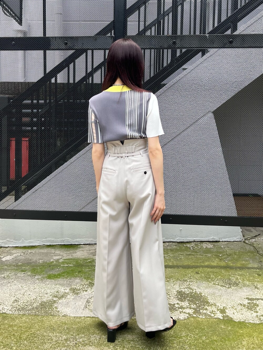 イエロー系のニット/セーター、グレー系のスラックスを着用したレディースの春コーディネートの4枚目の写真