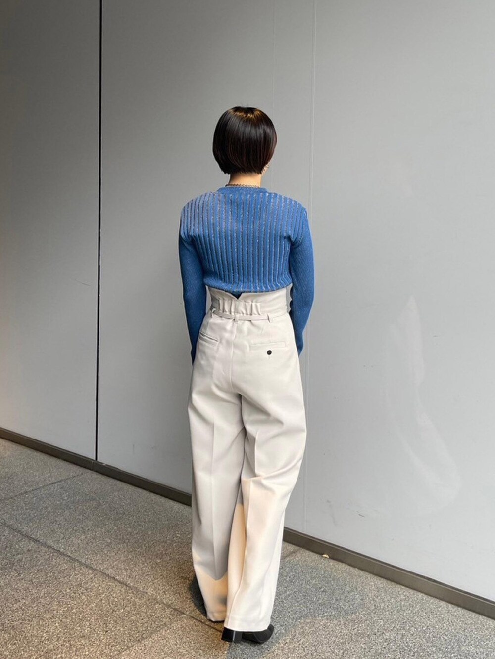ブルー系のニット/セーター、ホワイト系のその他パンツを着用したレディースの秋コーディネートの3枚目の写真