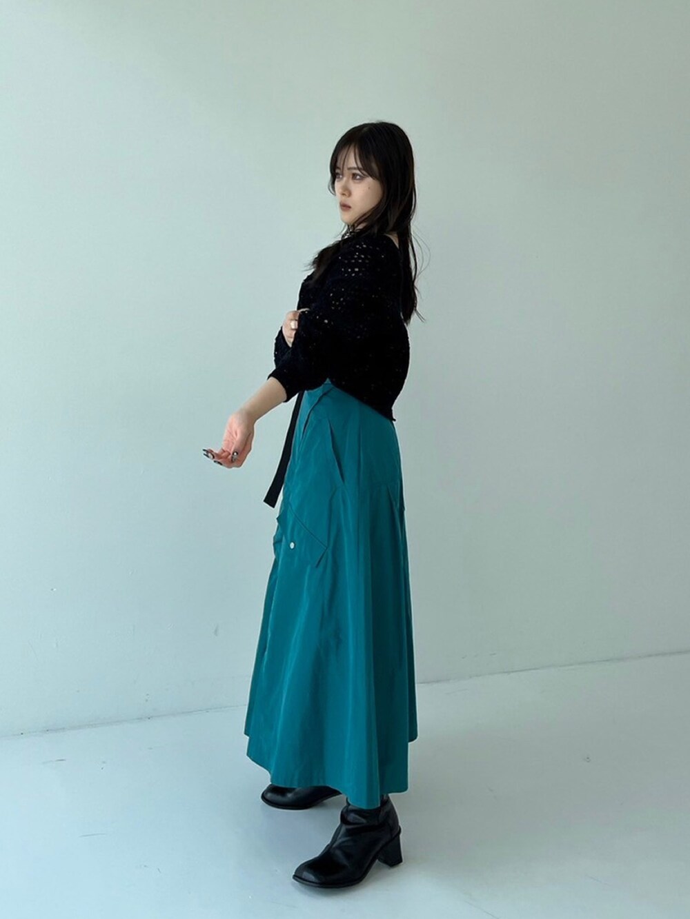 ブラック系のニット/セーター、グリーン系のスカートを着用したレディースの秋コーディネートの2枚目の写真