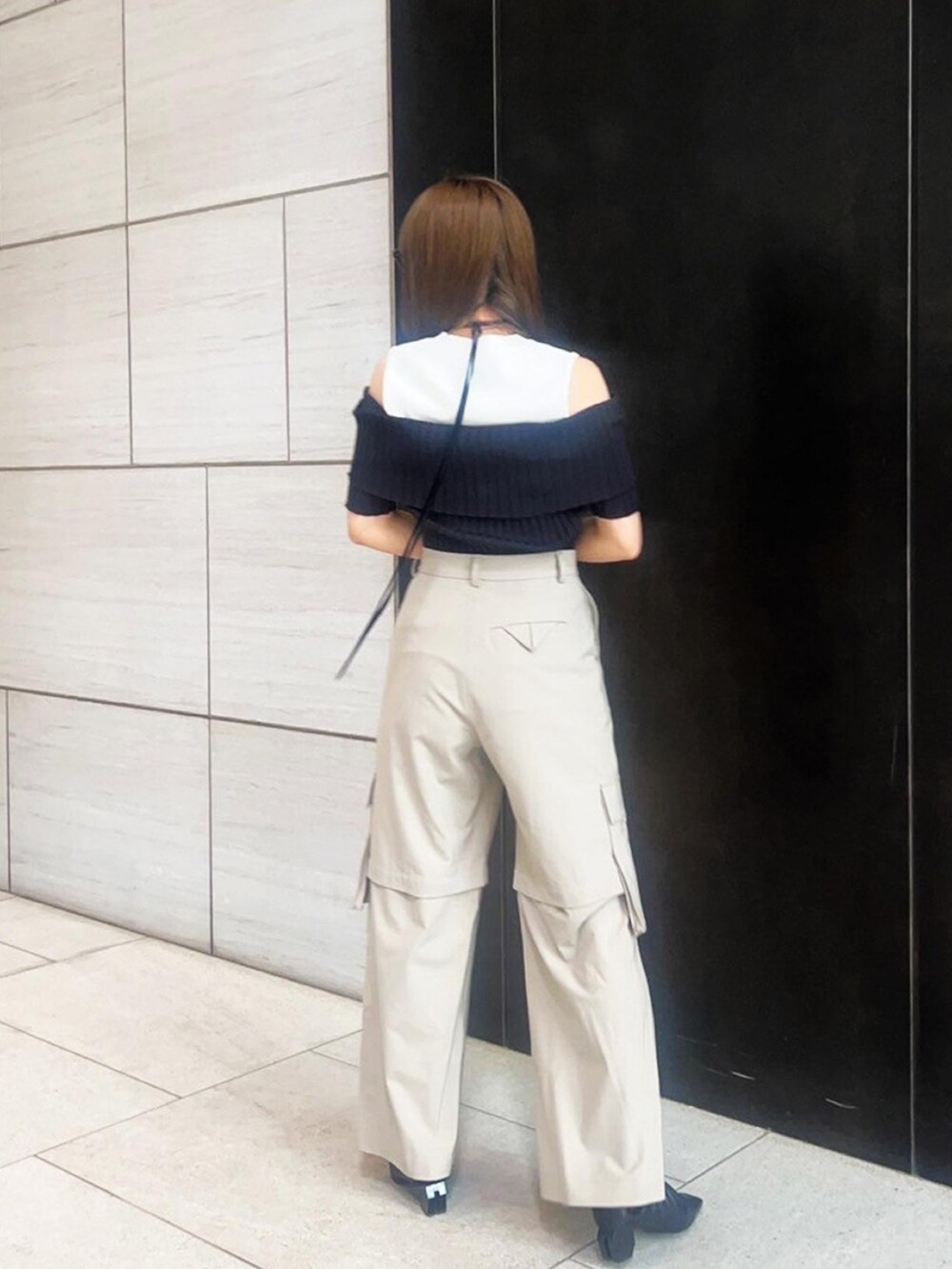 ベージュ系のカーゴパンツ、ブラック系のニット/セーターを着用したレディースの春コーディネートの3枚目の写真