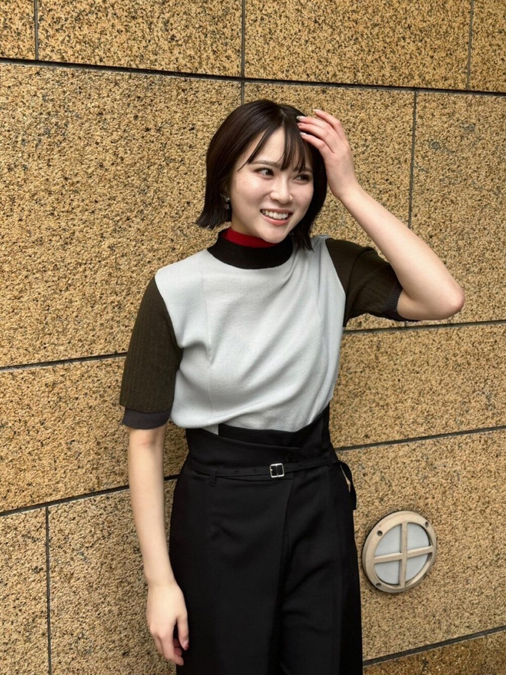 グレー系のニット/セーター、ブラック系のスラックスを着用したレディースの春コーディネートの5枚目の写真