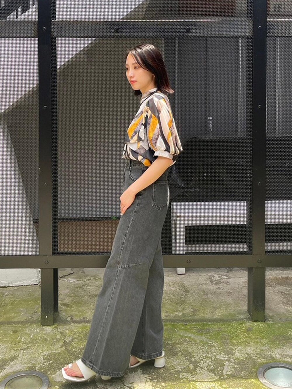 イエロー系のシャツ/ブラウス、ブラック系のデニムパンツを着用したレディースの春コーディネートの2枚目の写真