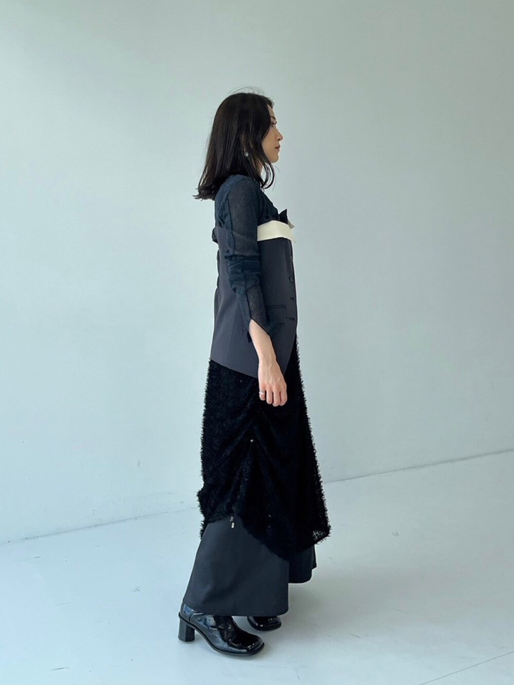 ブラック系のスカート、グレー系のキャミソール、ブルー系のTシャツ/カットソーを着用したレディースの秋コーディネートの2枚目の写真