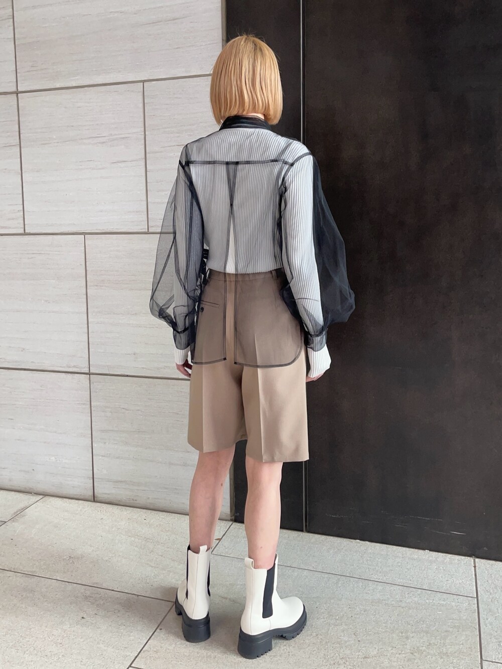 ブラック系のシャツ/ブラウス、ホワイト系のニット/セーター、ベージュ系のその他パンツを着用したレディースの春コーディネートの3枚目の写真