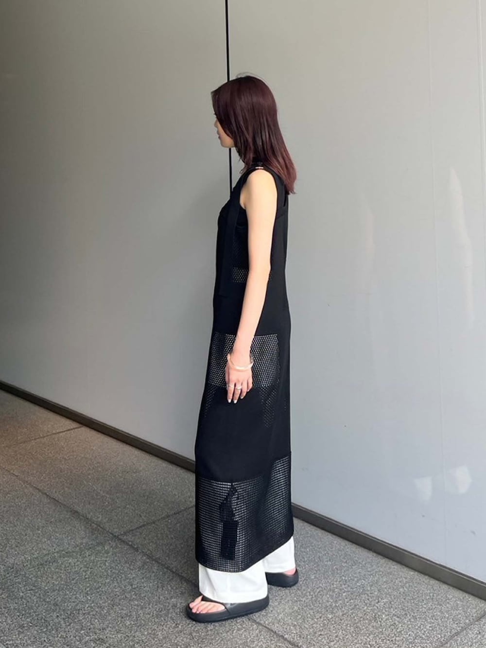 ブラック系のワンピース、ホワイト系のスラックスを着用したレディースの夏コーディネートの2枚目の写真