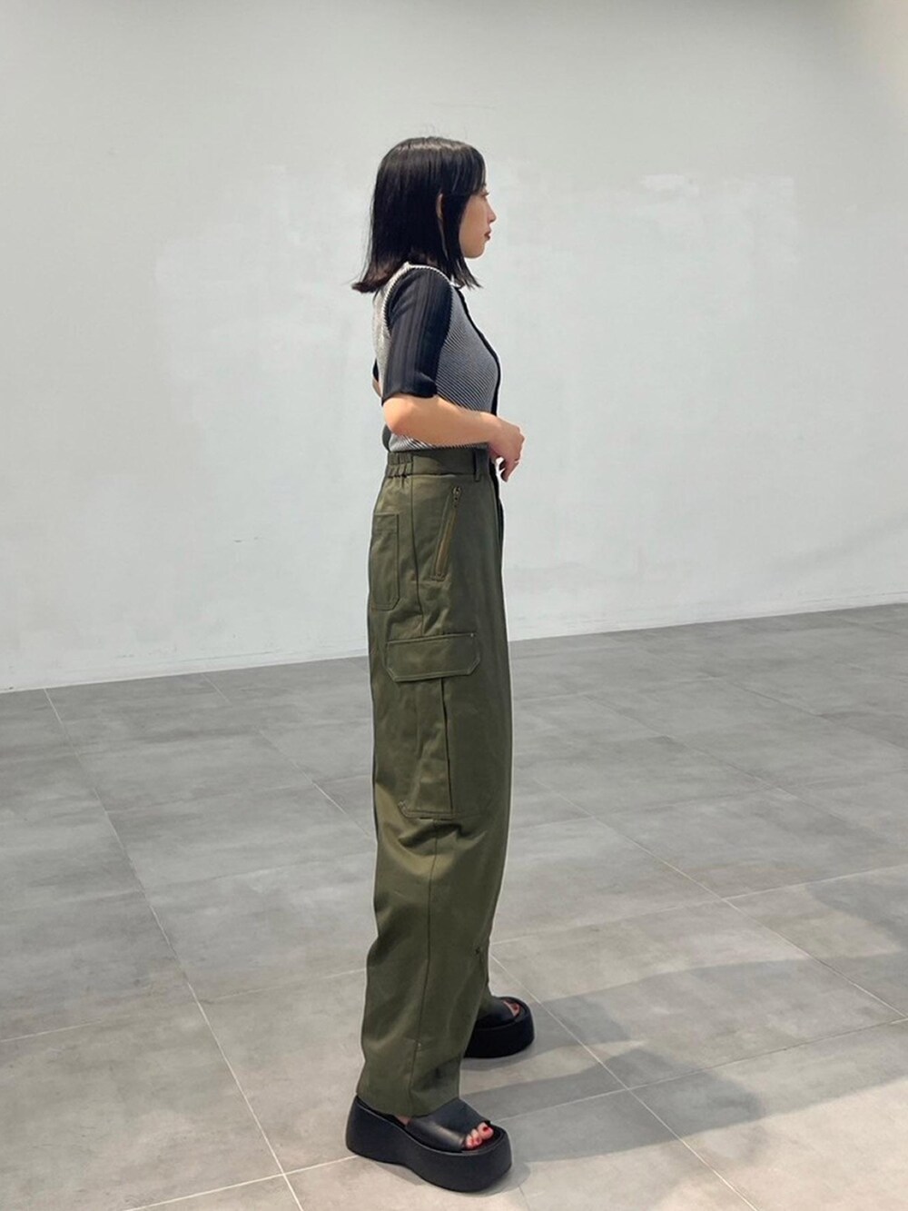 ブラック系のニット/セーター、グリーン系のカーゴパンツを着用したレディースの秋コーディネートの2枚目の写真