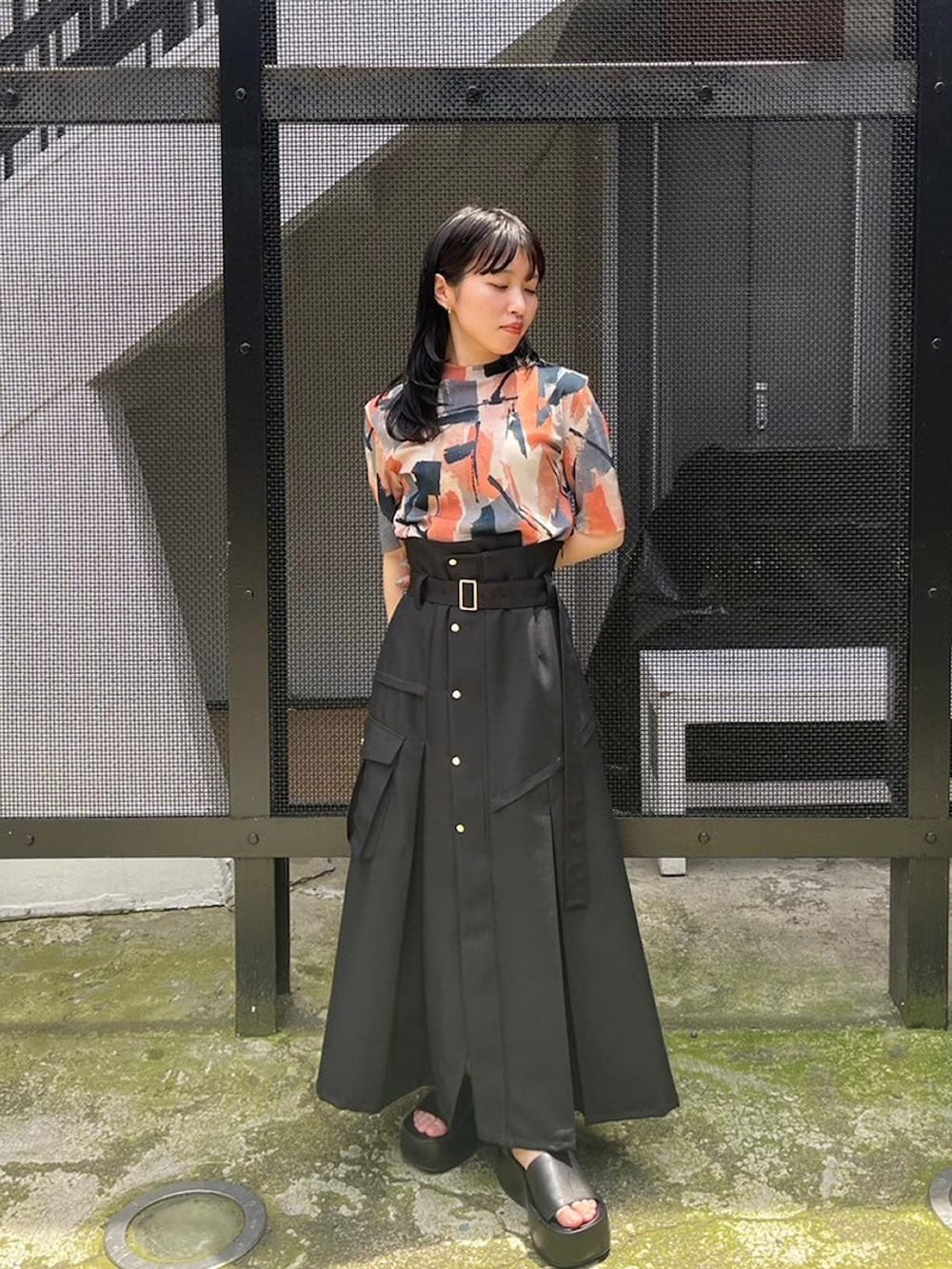 ベージュ系のTシャツ/カットソー、ブラック系のスカートを着用したレディースの春コーディネートの2枚目の写真