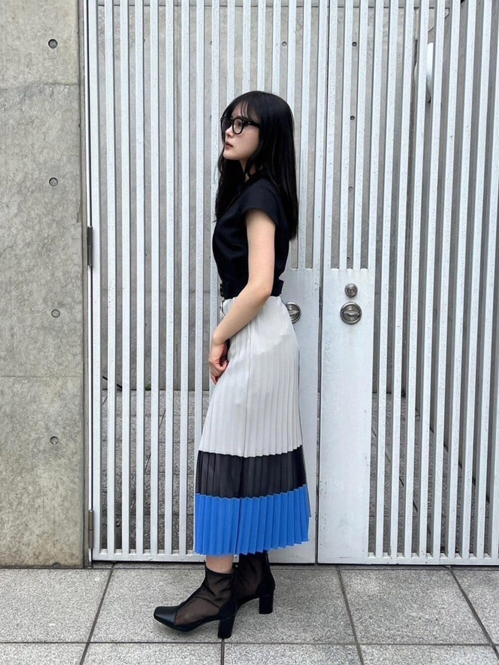 ブラック系のシャツ/ブラウス、ブルー系のスカートを着用したレディースの春コーディネートの2枚目の写真