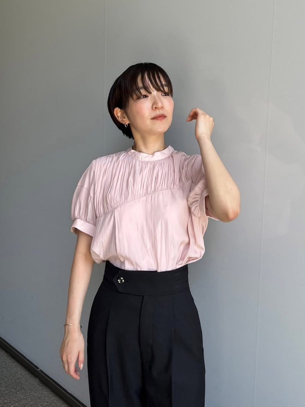 ピンク系のシャツ/ブラウス、ブラック系のスラックスを着用したレディースの夏コーディネートの2枚目の写真