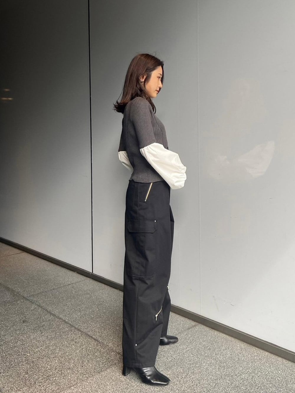 グレー系のニット/セーター、ブラック系のカーゴパンツを着用したレディースの秋コーディネートの2枚目の写真