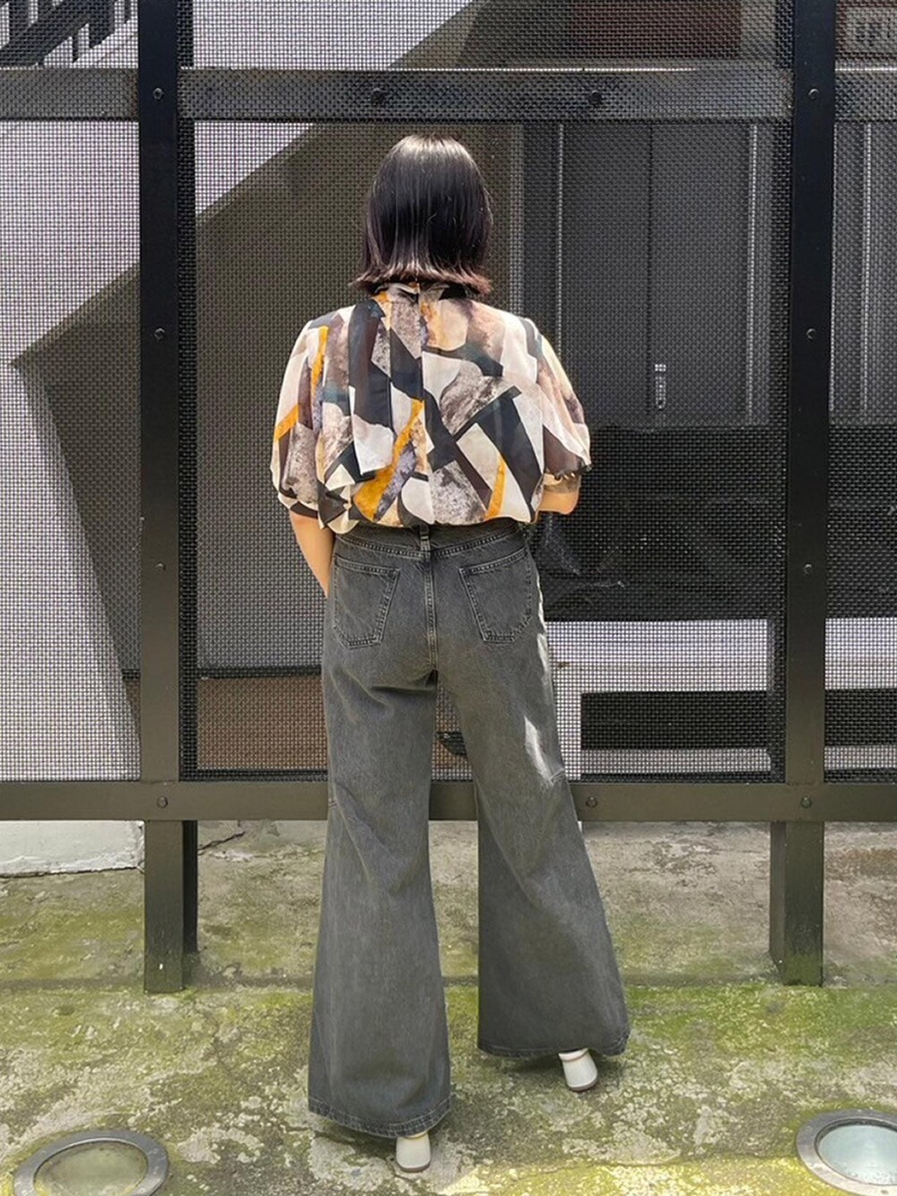 イエロー系のシャツ/ブラウス、ブラック系のデニムパンツを着用したレディースの春コーディネートの3枚目の写真