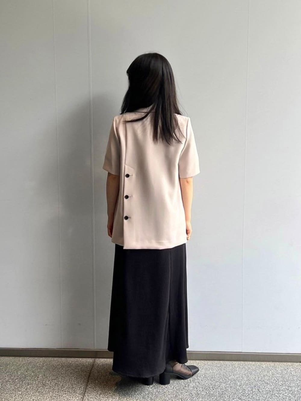 ベージュ系のテーラードジャケット、ブラック系のワンピースを着用したレディースの春コーディネートの3枚目の写真