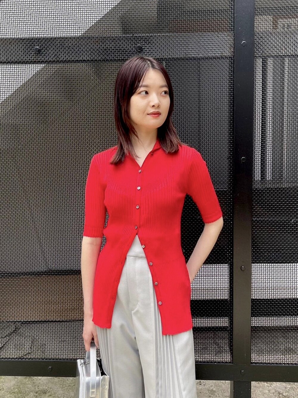 グレー系のその他パンツ、レッド系のニット/セーターを着用したレディースの春コーディネートの5枚目の写真