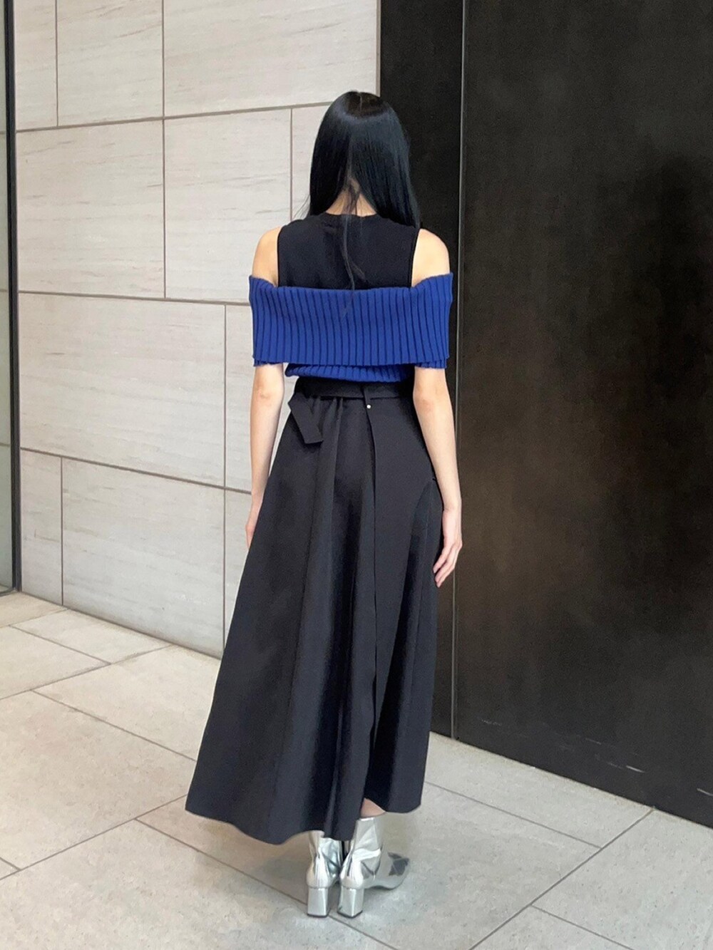 ブラック系のスカート、ブルー系のニット/セーターを着用したレディースの春コーディネートの3枚目の写真