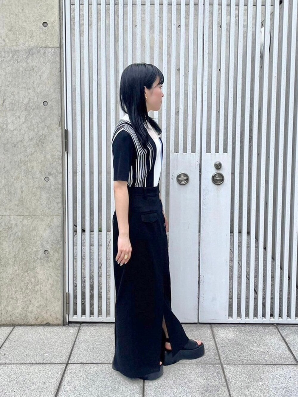 ブラック系のニット/セーター、ブラック系のスカートを着用したレディースの春コーディネートの4枚目の写真