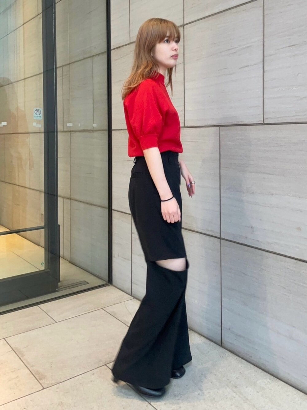 レッド系のニット/セーター、ブラック系のその他パンツを着用したレディースの春コーディネートの2枚目の写真