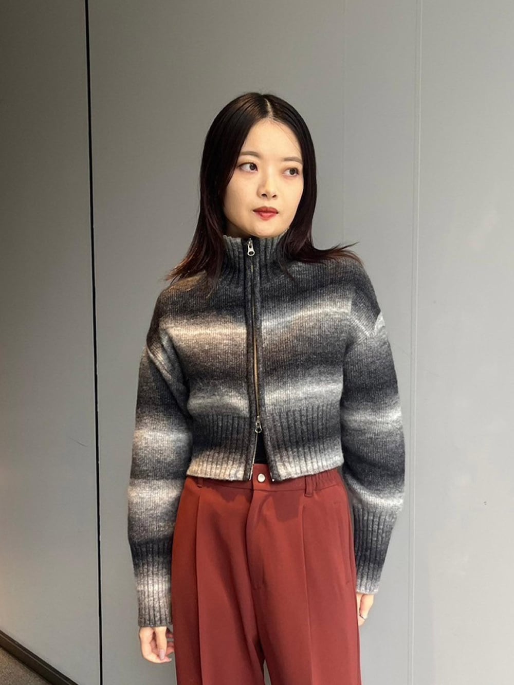 ブラック系のニット/セーター、レッド系のスラックスを着用したレディースの秋コーディネートの4枚目の写真