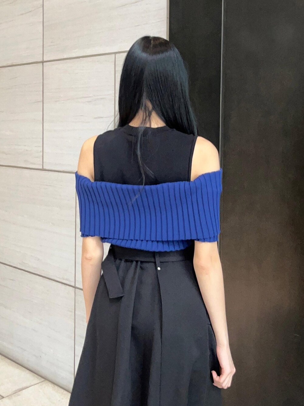 ブラック系のスカート、ブルー系のニット/セーターを着用したレディースの春コーディネートの6枚目の写真