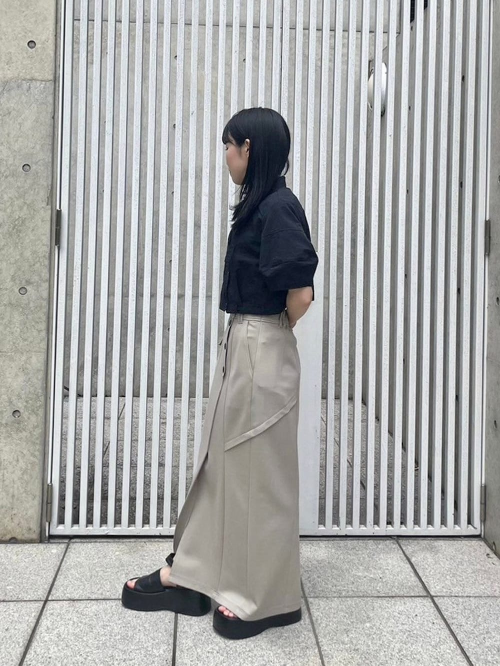 ブラック系のシャツ/ブラウス、ベージュ系のスカートを着用したレディースの春コーディネートの2枚目の写真