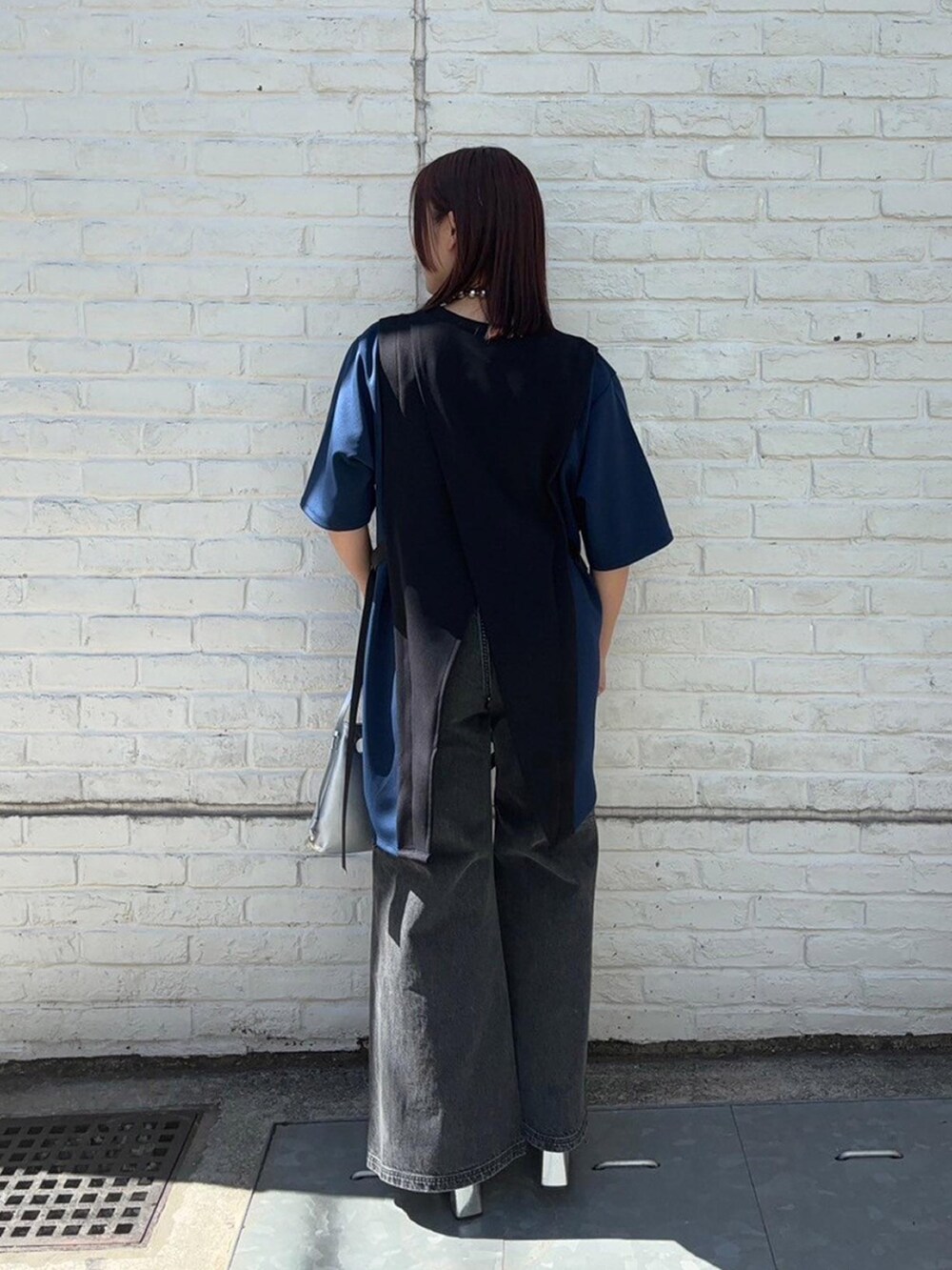 ブラック系のTシャツ/カットソー、ブラック系のデニムパンツを着用したレディースの春コーディネートの3枚目の写真