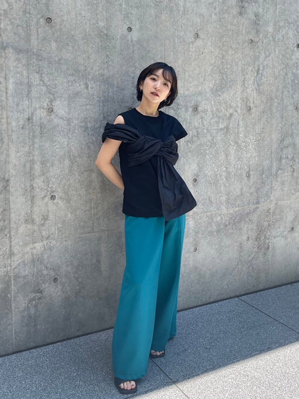 ブラック系のTシャツ/カットソー、グリーン系のスラックスを着用したレディースの夏コーディネートの2枚目の写真