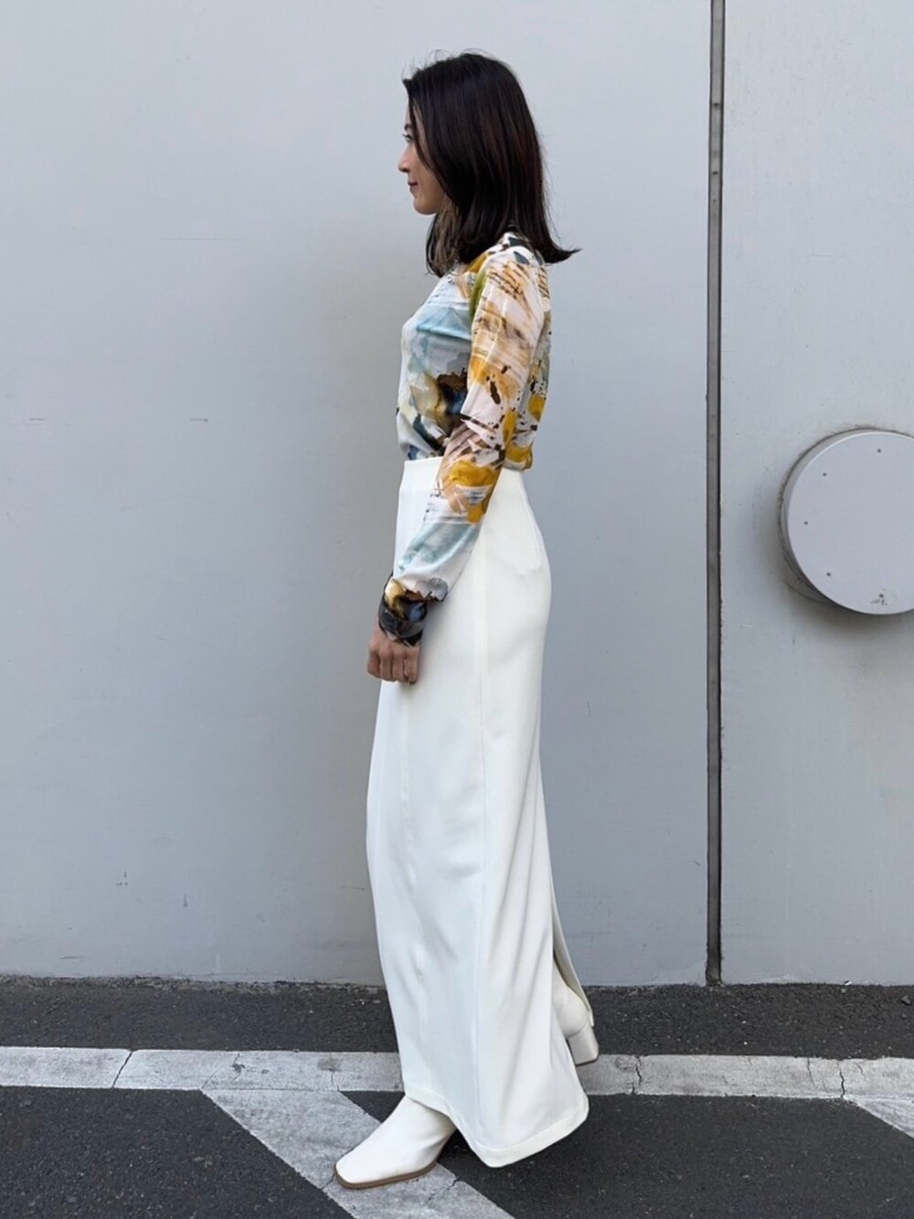 イエロー系のTシャツ/カットソー、ホワイト系のスカートを着用したレディースの冬コーディネートの2枚目の写真