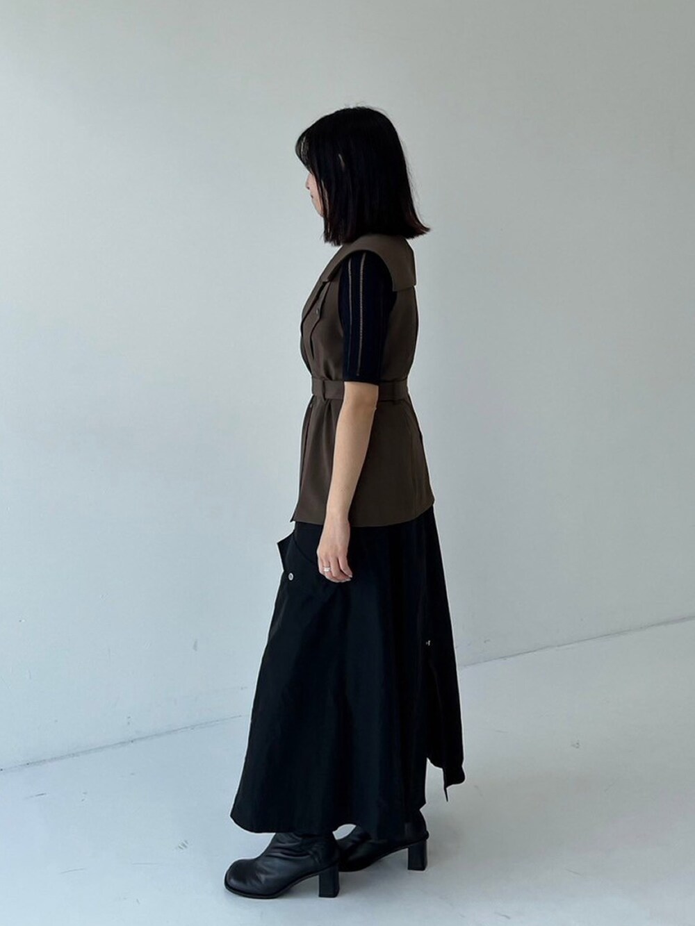 ブラック系のスカート、ブラウン系のテーラードジャケット、ブラック系のニット/セーターを着用したレディースの秋コーディネートの2枚目の写真