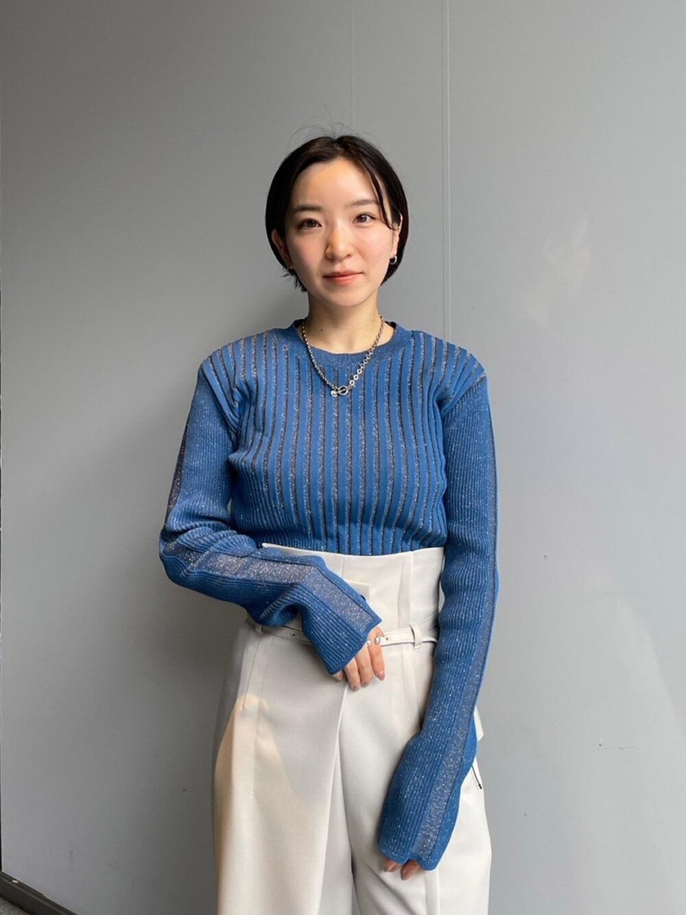 ブルー系のニット/セーター、ホワイト系のその他パンツを着用したレディースの秋コーディネートの4枚目の写真