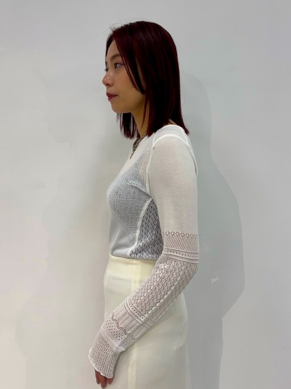 ホワイト系のニット/セーター、ホワイト系のスカートを着用したレディースの春コーディネートの6枚目の写真