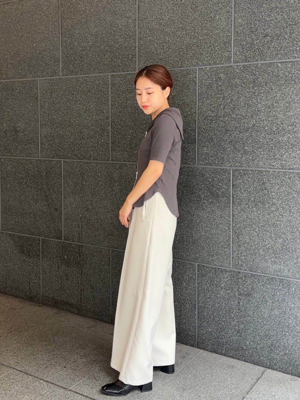 グレー系のTシャツ/カットソー、グレー系のスラックスを着用したレディースの夏コーディネートの2枚目の写真