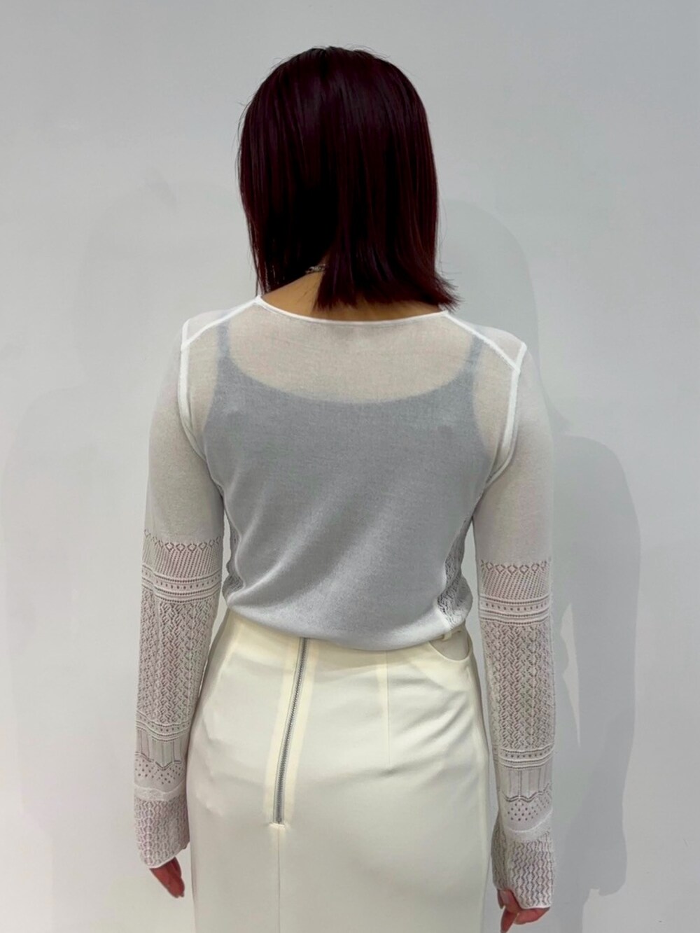 ホワイト系のニット/セーター、ホワイト系のスカートを着用したレディースの春コーディネートの7枚目の写真