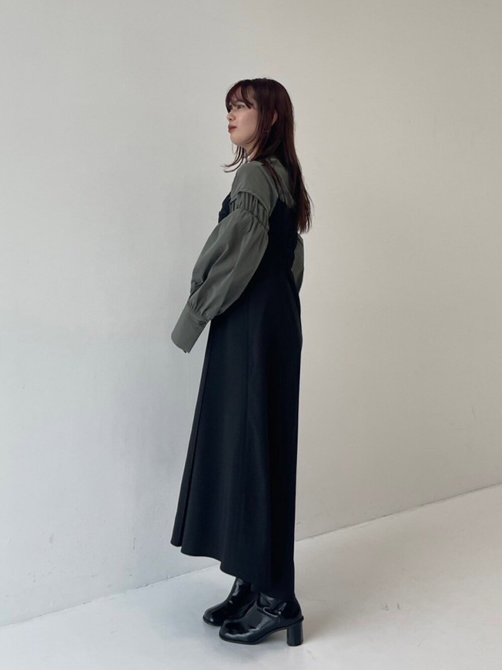 グリーン系のシャツ/ブラウス、ブラック系のワンピースを着用したレディースの秋コーディネートの2枚目の写真