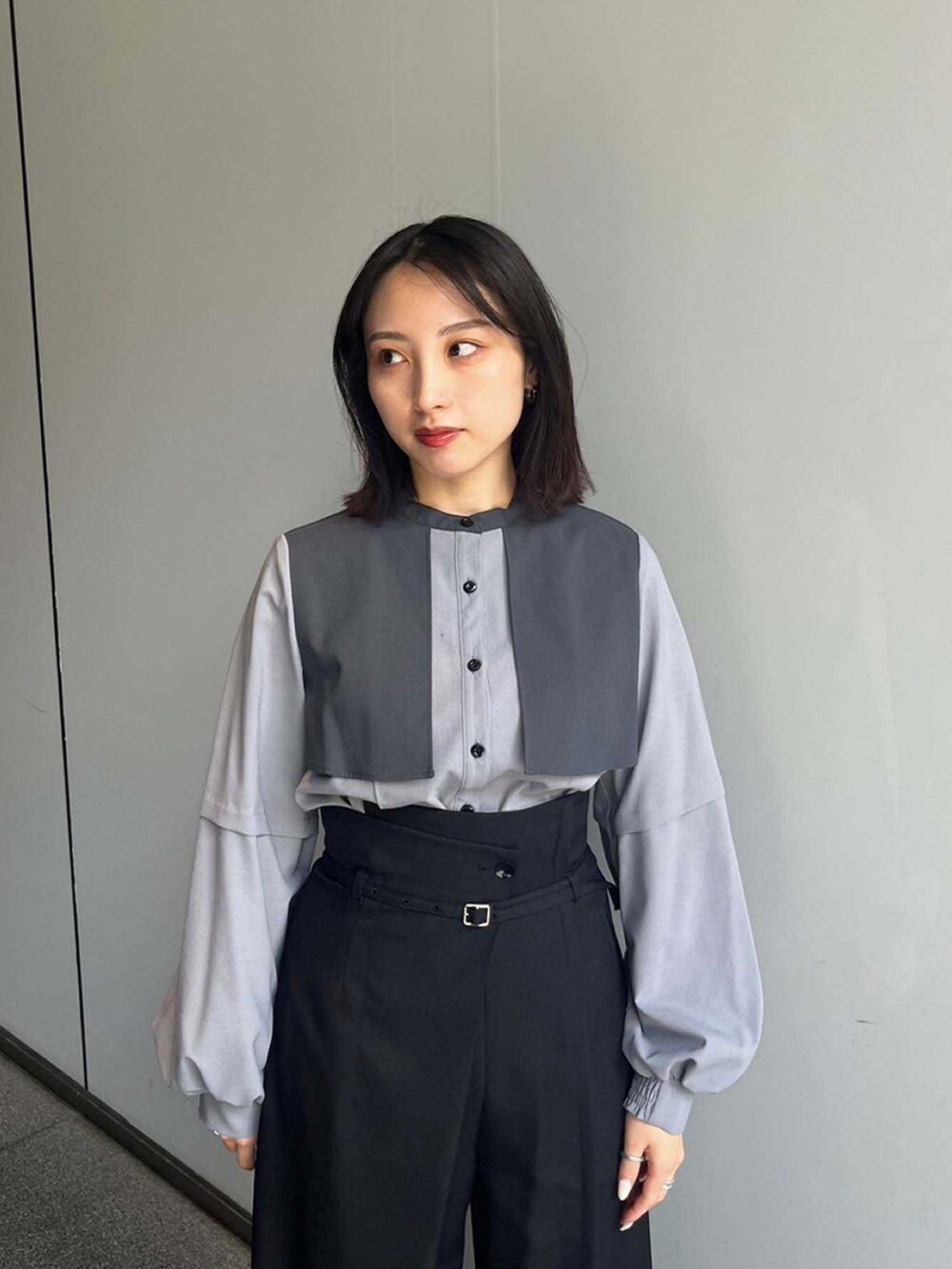 グレー系のシャツ/ブラウス、ブラック系のスラックスを着用したレディースの夏コーディネートの3枚目の写真