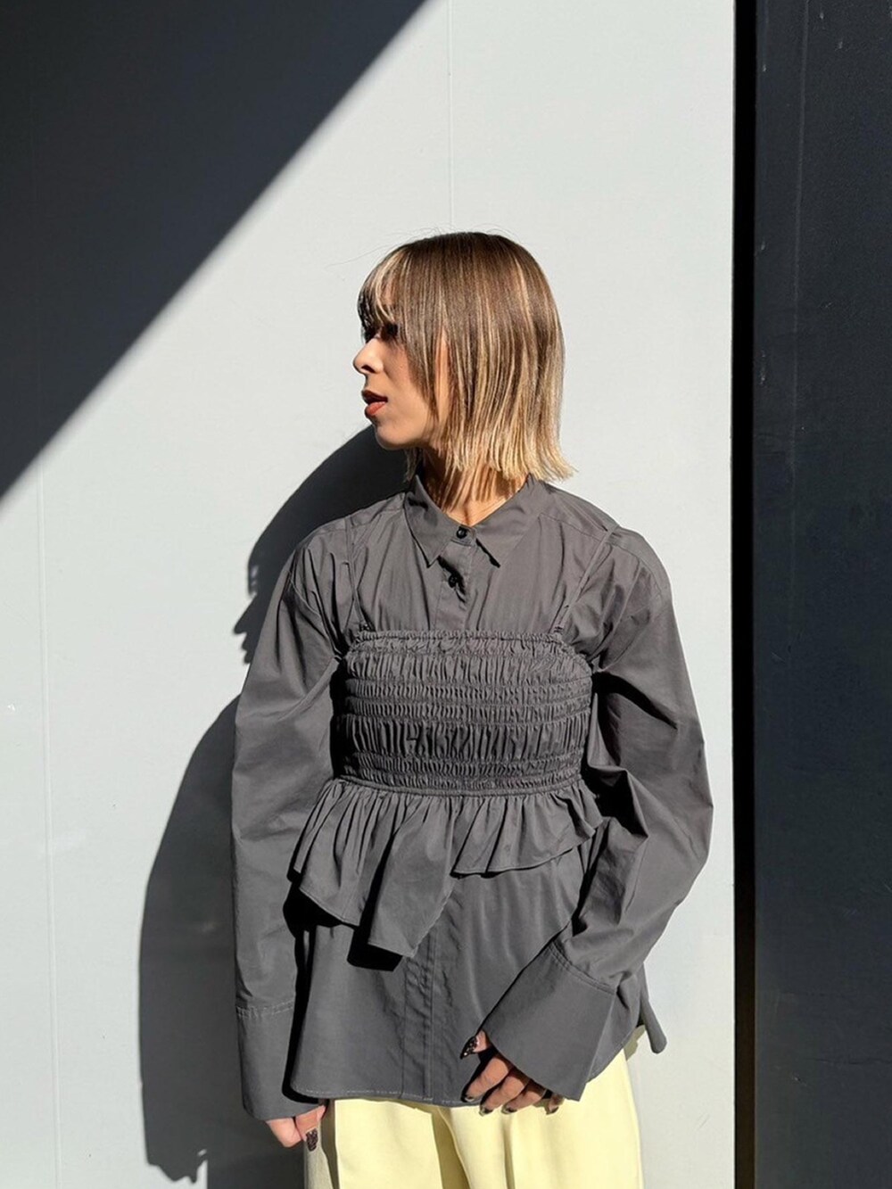 グレー系のシャツ/ブラウス、イエロー系のスラックスを着用したレディースの秋コーディネートの4枚目の写真